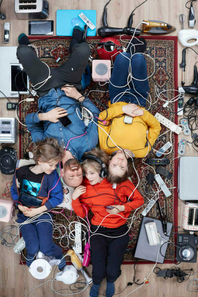 overhead shot of Rupert Boltes and his three light skinned children surrounded by household electricals photo by Gregg Segal