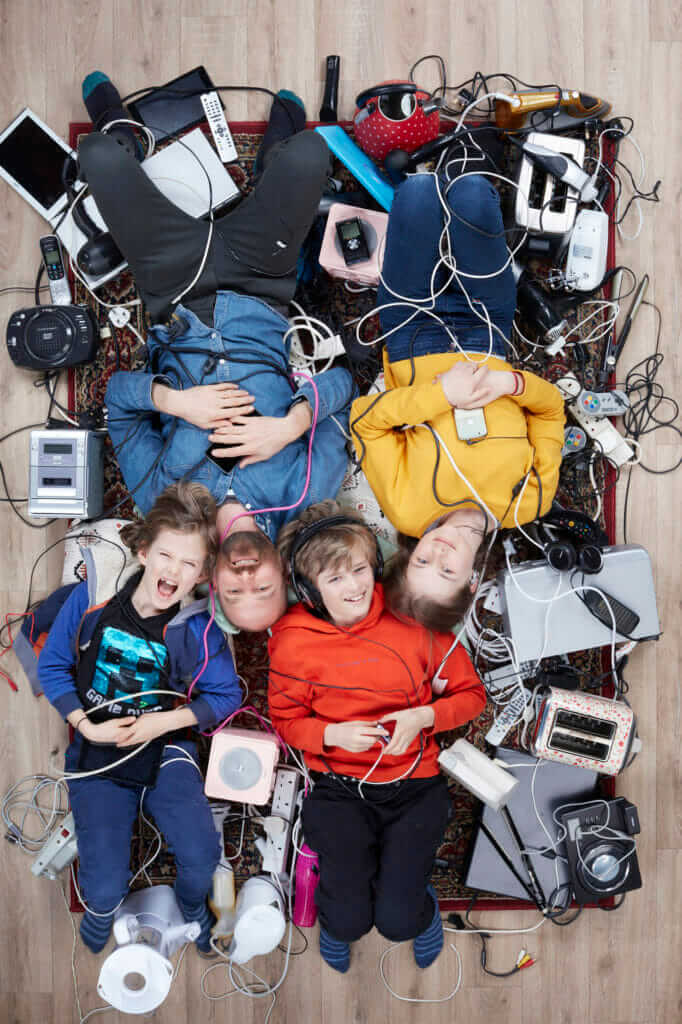 overhead shot of Rupert Boltes and his three light skinned children surrounded by household electricals photo by Gregg Segal