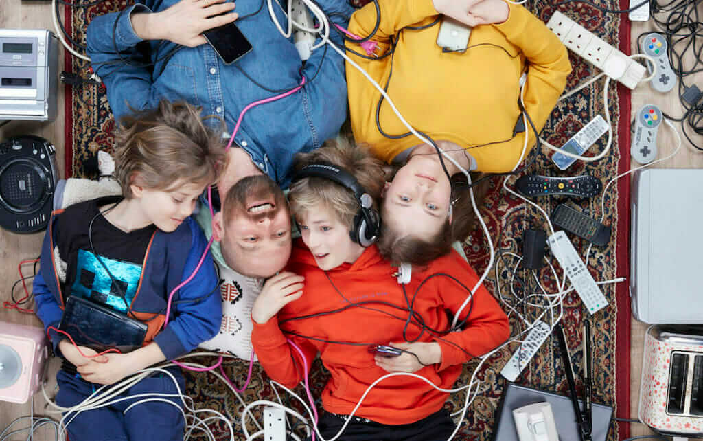 close up of Rupert Boltes and two light skinned children surrounded by household electricals photo by Gregg Segalchildren